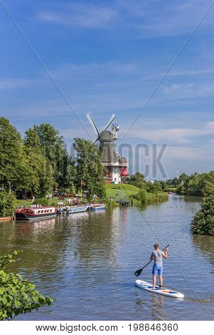 GREETSIEL, GERMANY - JULY 18, 2017: Young man enjoying standup paddleboarding in Greetsiel