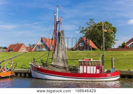 GREETSIEL, GERMANY - JULY 18, 2017: Red wooden fishing boat in the harbor of Greetsiel, Germany