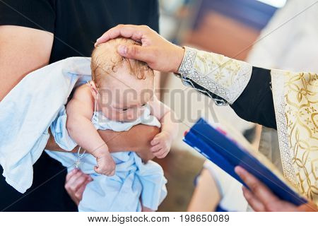 The sacrament of baptism. Newborn baby during christening and chrismation