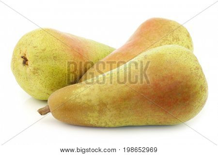 three fresh abate pears on a white background
