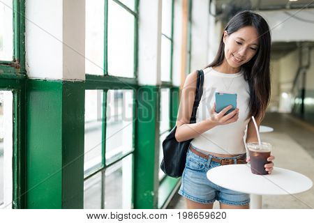 Woman using smart phone and enjoy her coffee in Hong Kong