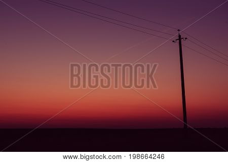 Single electric power pole on at sunrise, natural envirnomental clear energy background