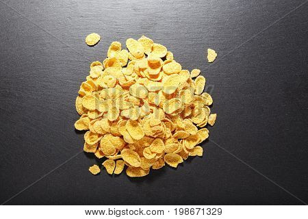 Corn flakes piled on a black background