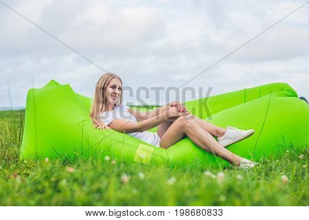 Young Woman Resting On An Air Sofa In The Park.