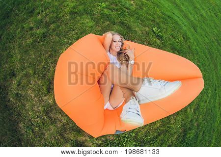 Young Woman Resting On An Air Sofa In The Park.
