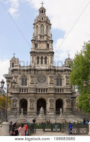 ParisFrance- April 29 2017: View of the Cathedral of the Holy Trinity on the Square d'Estienne d'Orves. People are resting on the lawn