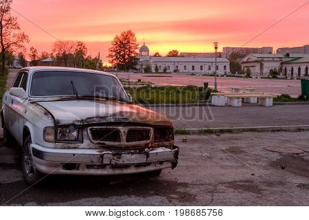 burned old car on sunset background russia
