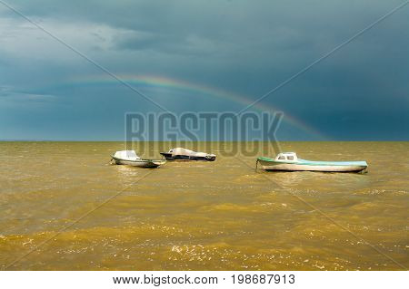 boats in the yellow waters of the Azov sea and rainbow