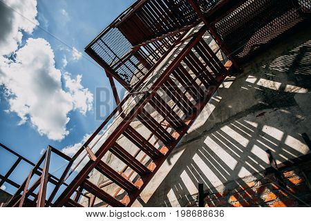 Abstract shot of iron fire staircase outside the building on a Sunny day