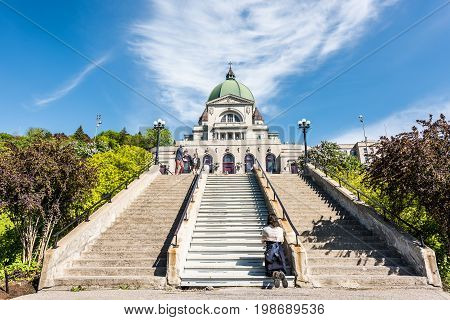 Montreal Canada - May 28 2017: St Joseph's Oratory on Mont Royal with woman praying on steps in Quebec region city