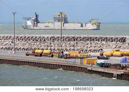 HARBOR CALAIS FRANCE - JUNE 07 2017: French harbor of Calais with dredging ship navigating outside of the harbor