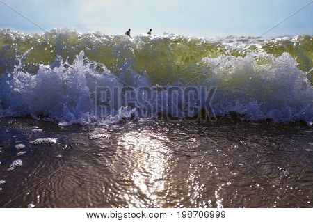 Swimmers enjoy the storm sea waves.sun set