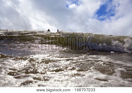 Swimmers enjoy the storm sea waves.sun set
