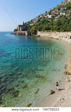 ALANYA TURKEY - JULY 04 2015: Shipyard (Tersane) and the ruins of a medieval fortress (Alanya Castle) on the mountainside.