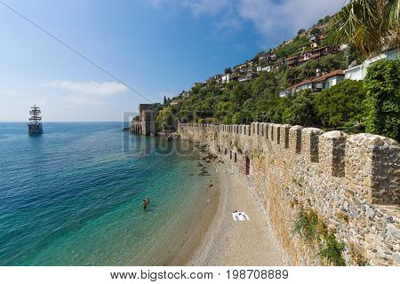 ALANYA TURKEY - JULY 04 2015: Shipyard (Tersane) and the ruins of a medieval fortress (Alanya Castle) on the mountainside.