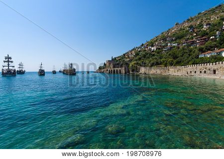 ALANYA TURKEY - JULY 04 2015: Shipyard (Tersane) and the ruins of a medieval fortress (Alanya Castle) on the mountainside.