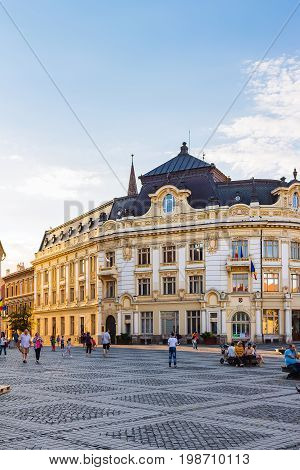 SIBIU ROMANIA - JUNE 19 2017: Large main square Huet with City Hall and tourists on the street ancient medieval city.