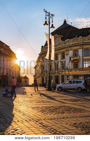 SIBIU ROMANIA - JUNE 19 2017: Large main square Huet with City Hall brukenthal museum at golden sun light ancient medieval city.