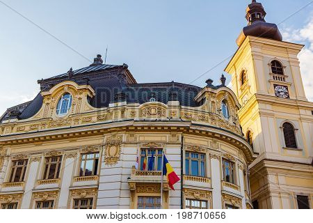 Facade of City Hall in baroque style and Catholic Church tower on Large square Huet in Sibiu city Romania.