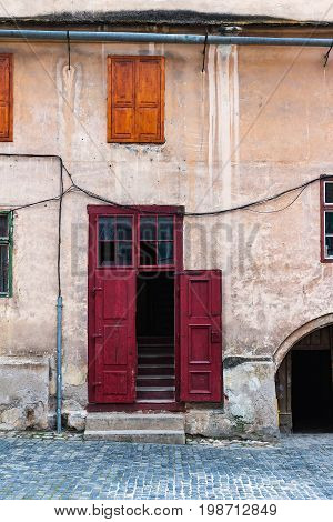 Detail of facade with red door in ancient house in Sibiu city Romania.