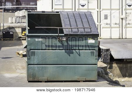 Waste bin located in an alley alongside a building