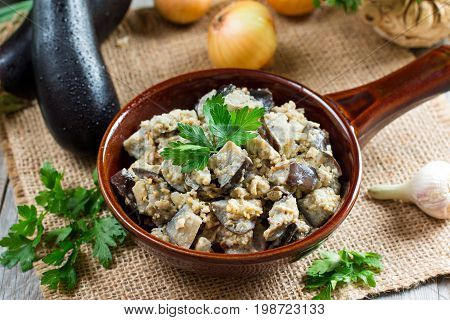Eggplants with vegetables and sour cream on a wooden background