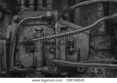 Old dirty diesel tractor engine with soot and oil. Black and white photo.