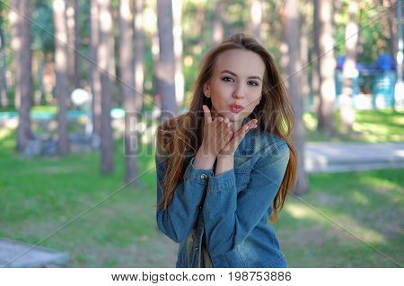 sexy beautiful woman showing air kiss in the park