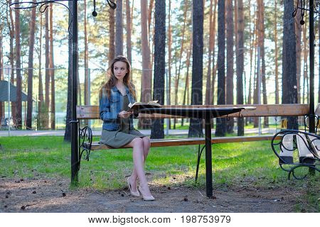 beautiful girl reading a book outdoor in the park