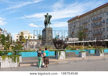 MOSCOW - AUGUST 7: Two women Yuri Dolgoruky monument and flower beds in Tverskaya Square on August 7 2017 in Moscow. Flower beds were installed during 