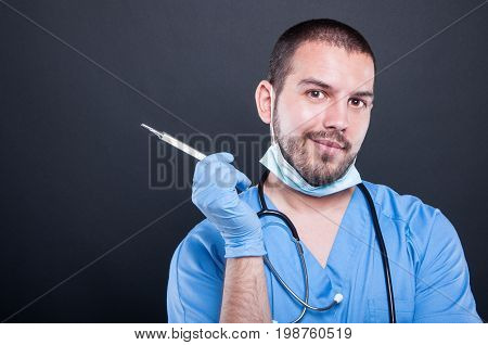 Doctor Wearing Scrubs Holding Thermometer