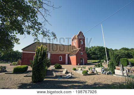 Laesoe Denmark - July 28 2017: Vesteroe red church and cemetery on Laesoe island in Kattegat Sea Denmark.
