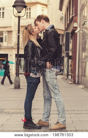 Young cute couple kissing in urban surroundigs.