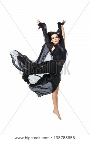 Beautiful modern dancer young woman in black flyings fabrics making dance moves. Isolated on white background. Copy space.