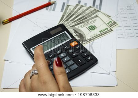 Accountant counts money with a blach calculator