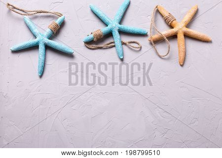 Border from marine items on grey tetured slate background. Sea objects. Selective focus. Place for text.