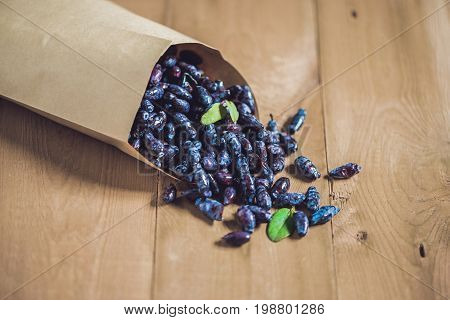 Fresh Honeysuckle Blue Berry Fruits With Leaf On A Wooden Background