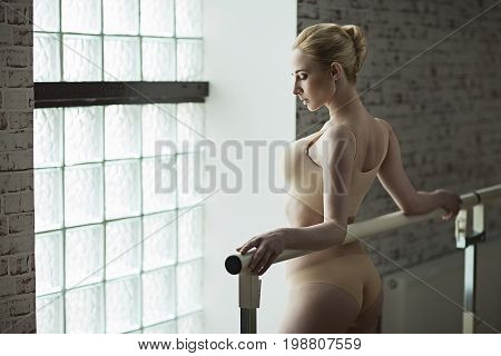 Slender Blonde Girl Ballerina In Bright Dancing Hall. Woman With Big Breast And In Beige Underwear S