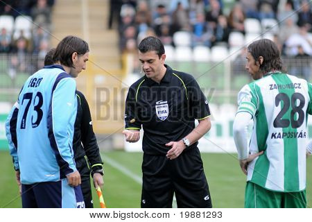 KAPOSVAR, Hungria - 27 de março: Árbitro de Viktor Kassai (C) em ação em um Championsh Nacional Húngaro