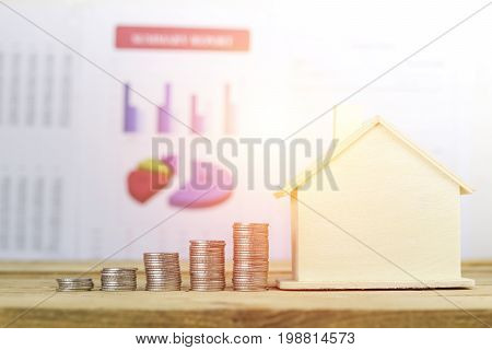 pile of coins home concept in buying selling and mortgage house finance on wood table