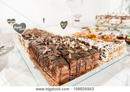 Chocolate cake with hazelnut. Delicious wedding reception candy bar Dessert table for a wedding outdoor party