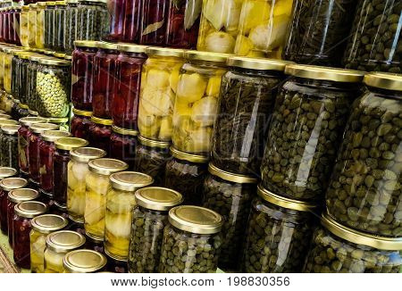 Rows of colorful glass canning jars filled with food from grandmother's kitchen.