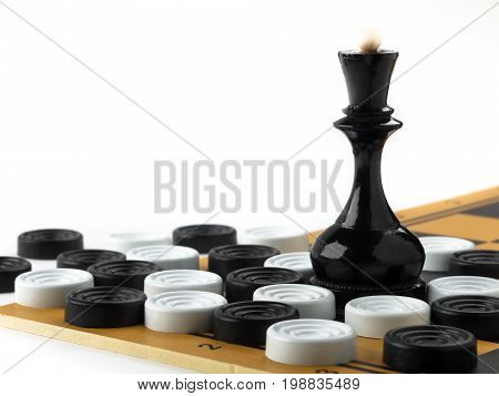 The chess queen and checkers placed on the chessboard. White background