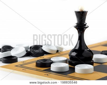 The chess queen and checkers placed on the chessboard. White background