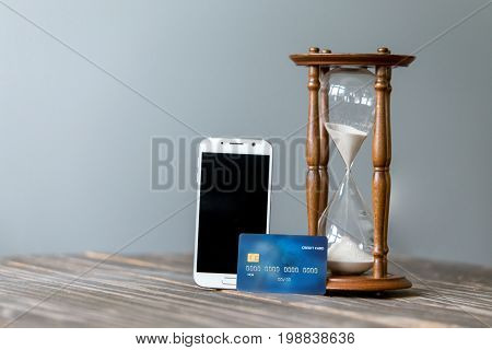 Credit card and mobile smart phone, Online shopping. Concept of time management. Sand clock