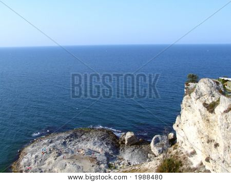 Stenig klippa och stranden