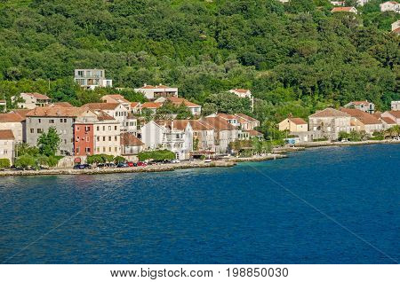 Prcanj - a small town along the Bay of Kotor Montenegro. A part of the waterfront that consists of a long line of stone villas.