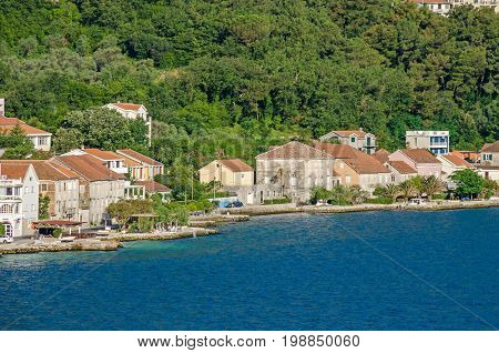 Prcanj - a small town along the Bay of Kotor Montenegro. A part of the waterfront that consists of a long line of stone villas.