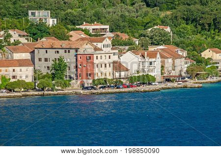 Prcanj - a small town along the Bay of Kotor Montenegro. A part of the waterfront that consists of a long line of stone villas.
