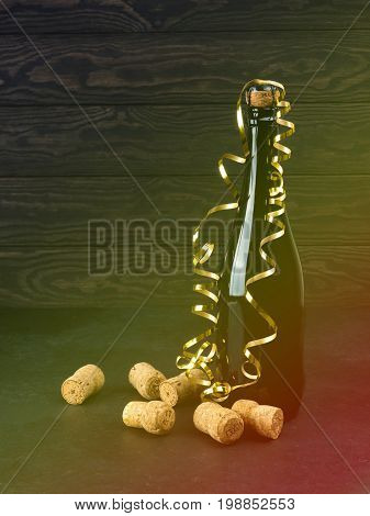 Wine Bottle On Wood Floor And Grunge Background, Nearby Cork, Tinsel, The Concept Of The Celebration